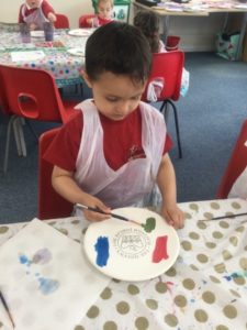 A young boy from the Nursery can be seen decorating a ceramic plate in celebration of the Queen's Platinum Jubilee.